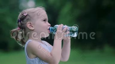喝水。小女孩在户外用瓶子喝水